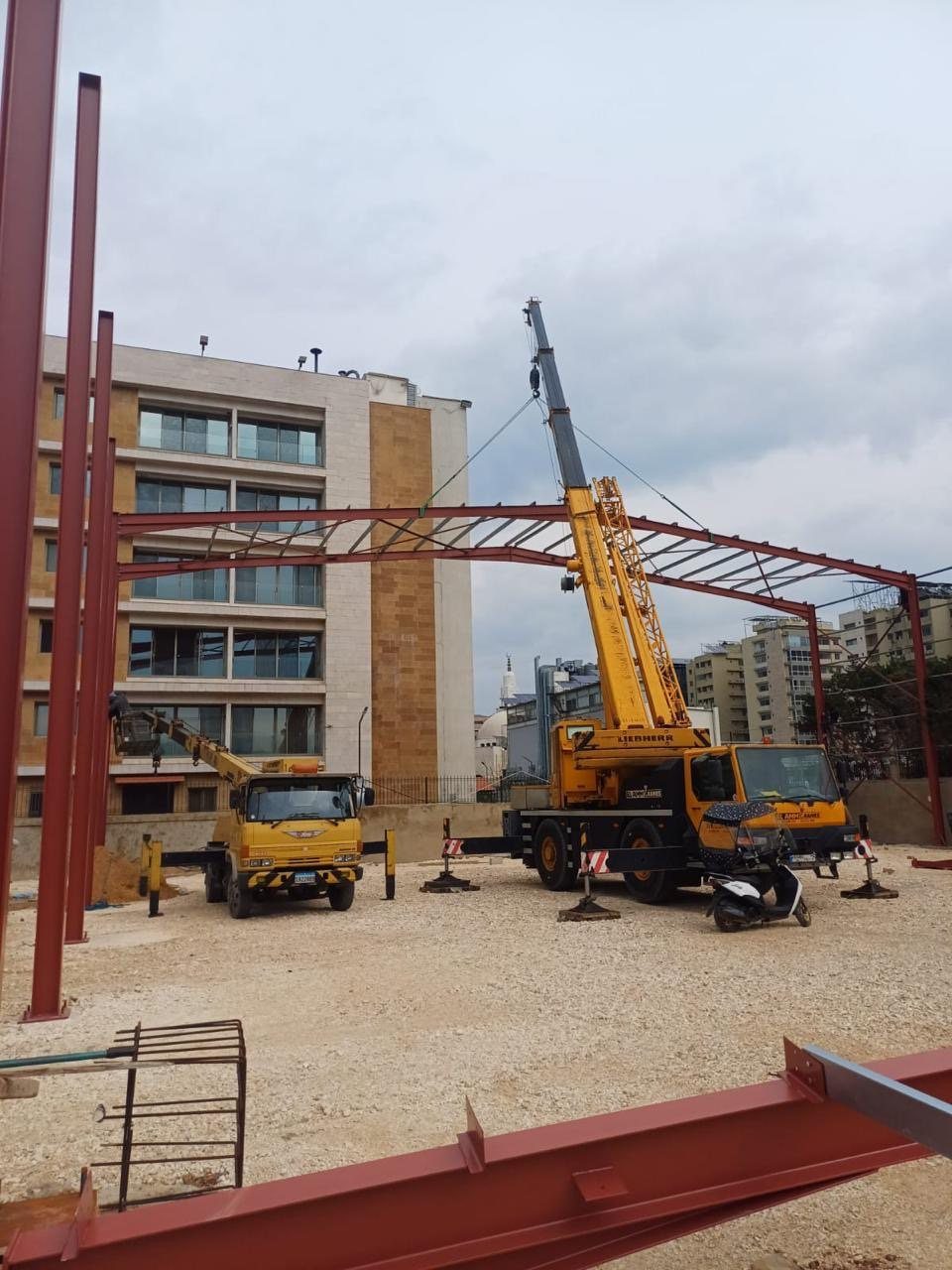 Mobile cranes erecting a steel portal frame on an urban site in Lebanon